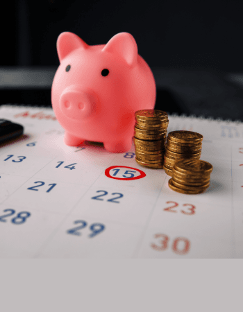 Piggy bank and coins on a calendar
